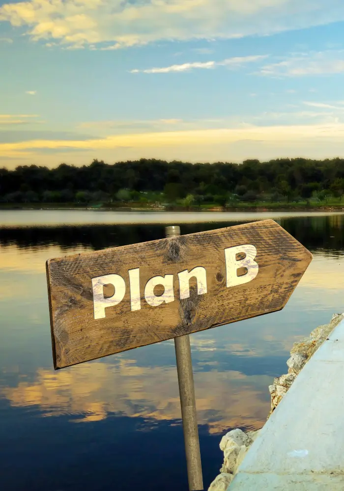 Navigating Redundancy Plan B wooden sign on river
